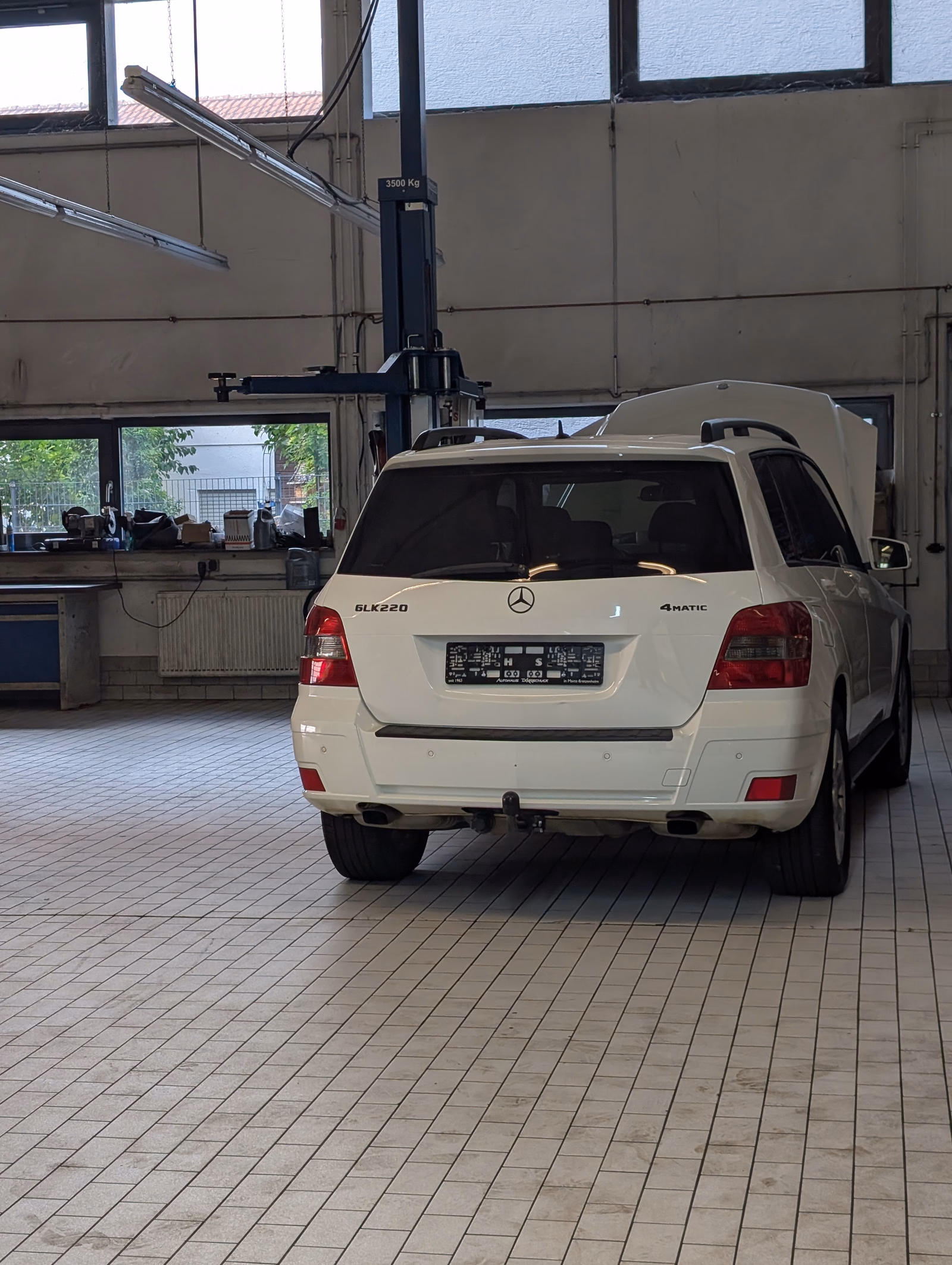 Weißes Fahrzeug an einem Arbeitsplatz in der Meisterwerkstatt von Autohaus Dörrschuck in Mainz